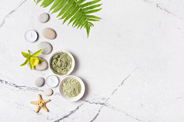 Obraz na płótnie Canvas Spa background with cosmetic clay, sea stones and aroma candles