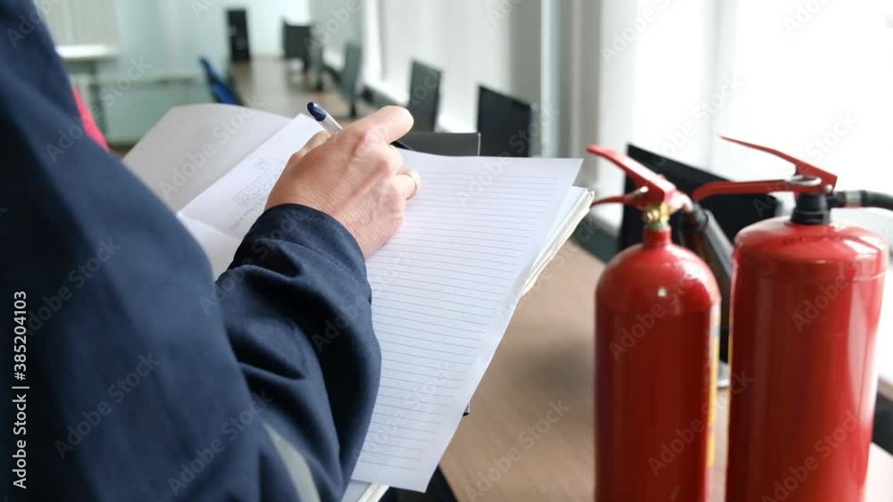 Wall mural engineer professional are checking a fire extinguisher and writes data to the check log. fire alarm 