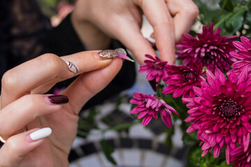 Fototapeta premium Girl tears off a petal from a pink chrysanthemum 