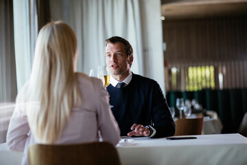 Handsome businessman dressed in the suit drinking wine. Businessman enjoying in the restaurant...