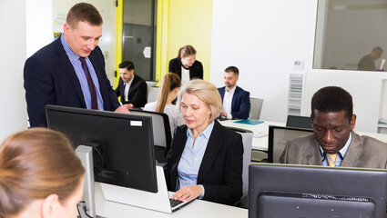 Successful coworkers engaged in business activities in busy open plan office.