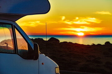 Camper vehicle on beach at sunrise