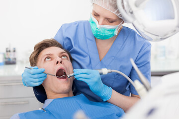 Young man on dental checkup in modern dentist office. High quality photo