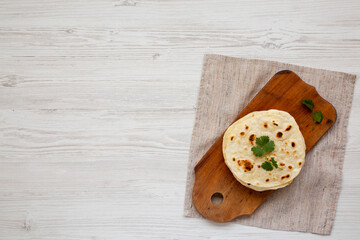 Homemade Roti Chapati Flatbread on a rustic wooden board, top view. Overhead, from above, flat lay. Space for text.