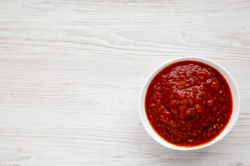 Obraz na płótnie Canvas Homemade Tomato Salsa on a white wooden background, top view. Flat lay, overhead, from above. Space for text.