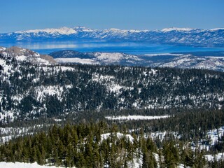 snow covered mountains, trees and lake 