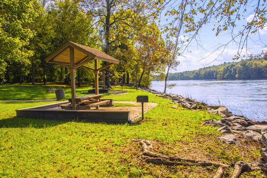 A Picnic Area In A Park With Tables And Grills