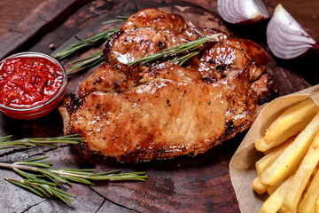 Fried meat with spices and vegetables on a wooden board. European cuisine.