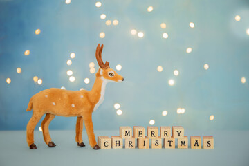 Merry Christmas greetings background with deer and bokeh lights