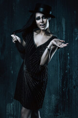 Naklejka premium emotional woman in black dress and hat