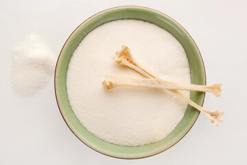 White Collagen powder and bones with copy space from above.