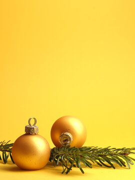Two golden vintage Christmas baubles on a yellow background with space for your text or image, seasonal holiday concept