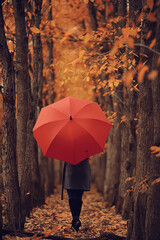 autumn evening woman holds umbrella, october in dark city park, young lonely model with umbrella