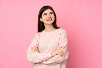 Fototapeta premium Young Ukrainian teenager girl over isolated pink background looking up while smiling