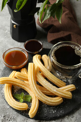 Concept of lunch with churros and chocolate on dark table