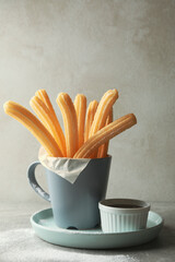 Concept of sweet lunch with churros on gray table
