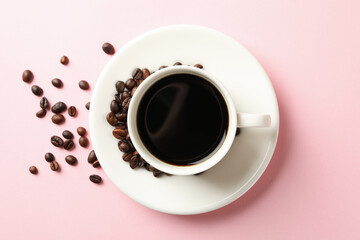 Cup of coffee and beans on pink background