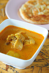 Thai massaman curry with chicken in a bowl and rice on the table close-up.