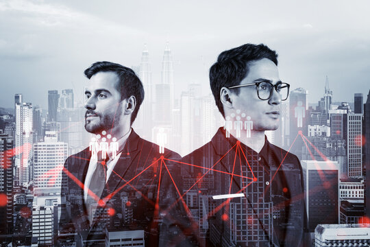 Two handsome young SMM specialists thinking about development of social media marketing strategy to achieve business goals. Hologram icons over Kuala Lumpur background. - Powered by Adobe