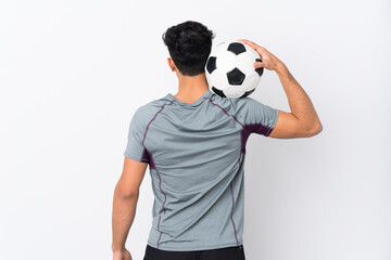 Young Argentinian man over isolated white background with soccer ball