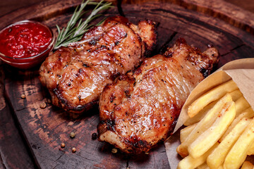Fried meat with spices and vegetables on a wooden board. European cuisine.