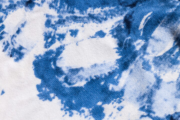 Tie-dye cotton fabric texture blue and white paint colors. Ancient resist-dyeing textile coloring technique, saturated primary colors, bold patterns, simple motifs, monochromatic color schemes garment