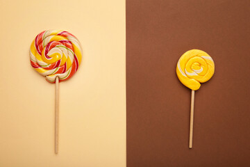Two colorful sweet lollipops for children on brown