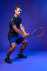 Young tennis player in action against purple background