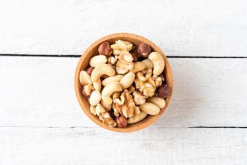Various kinds of nuts in bowl on wooden background. Top view