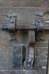 Vertical photo of an old lock of a rusty door and with the old wood