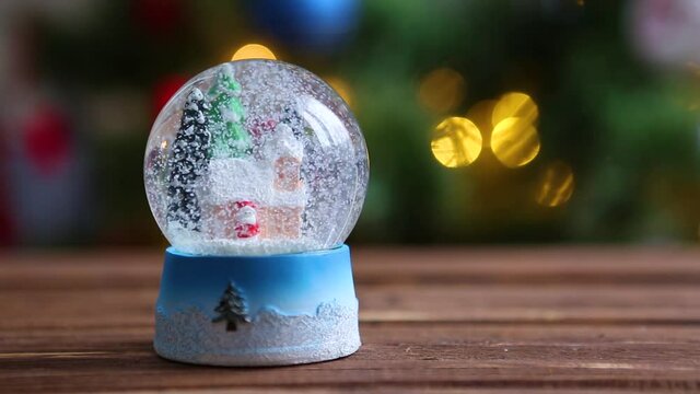 Christmas snow glass ball on background of christmas tree with christmas lights