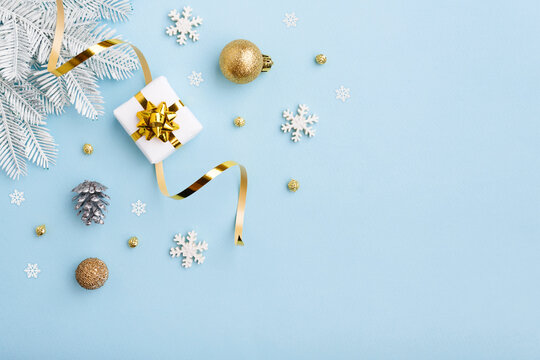 Christmas gift with gold bow and decoration on blue background