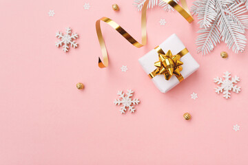 Christmas gift with snowflakes and decoration on pink pastel background
