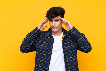 Young Argentinian man over isolated yellow background unhappy and frustrated with something. Negative facial expression