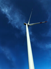 Wind turbine against the background of the    dramatic sky with clouds