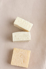 a stack of handmade soap on a beige fabric background, natural spa cosmetics. flat lay, copy space