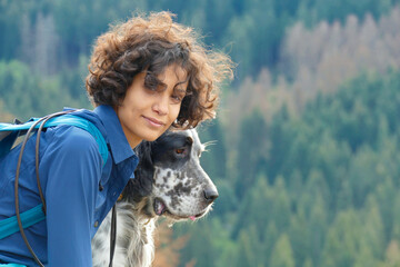 Portrait of a young Woman and an English Setter dog on a hike in the mountains with copy space