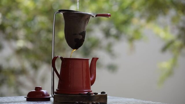 rustic coffee in cloth sieve and red teapot