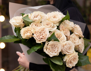 Young woman with a gift bouquet of peonies roses, mono bouquet of roses. Young woman holding fresh bouquet of roses.