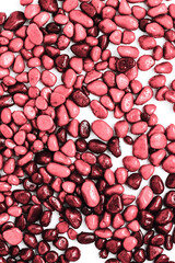 beautiful texture of stones in drops on a white background. red pebbles, top view, flat lay