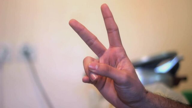 Man hand holding up the peace sign or number two with two fingers