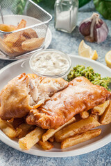 Fish in beer batter and chips with green pea and tartar sauce