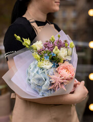 Colorful flowers assorted bouquet in bright paper. Holiday celebration concept. Bouquet of beautiful flowers in hands. Colorful flowers bouquet wrapped in paper
