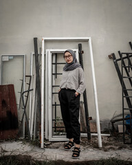 Obraz na płótnie Canvas Beautiful Asian Muslim woman posing and stylish with the background of junk and scrap metal.