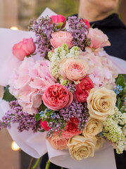 Colorful flowers assorted bouquet in bright paper. Holiday celebration concept. Bouquet of beautiful flowers in hands. Colorful flowers bouquet wrapped in paper