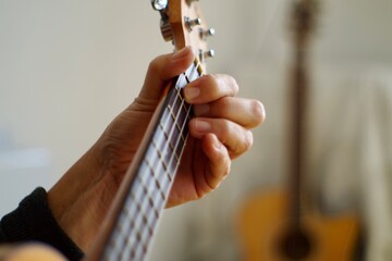 close up of a person playing the ukulele guitar