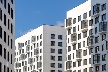 Fototapeta premium Multi-storey residential buildings with balconies. Laconic design in light colors. Modern apartments