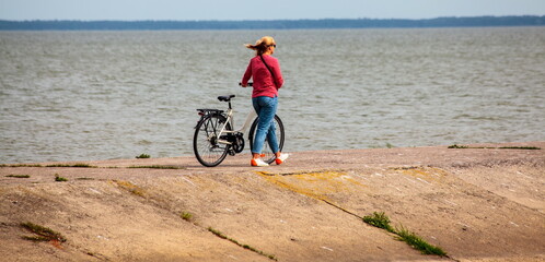 A woman with a bicycle on a pier