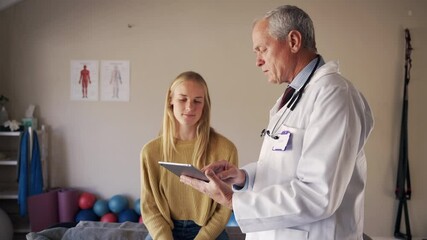 Senior male doctor holding digital tablet showing test results to patient at rehabilitation center - Powered by Adobe