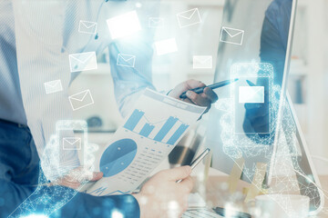 Envelop holograms with businessman working on computer on background. E-mail concept. Multi...